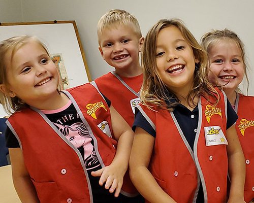 Children in red vests laughing
