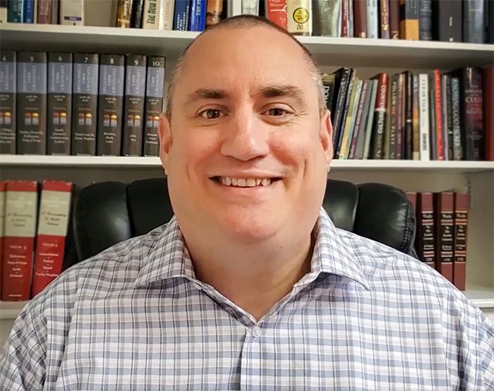 Smiling Pastor Brian Winburn in office wiht books